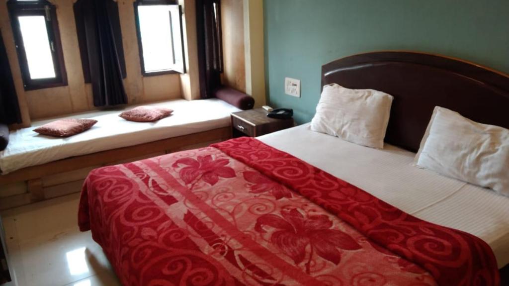 - une chambre avec 2 lits et des couvertures rouges et blanches dans l'établissement Jaisalmer Hotel Meotrips, à Jaisalmer