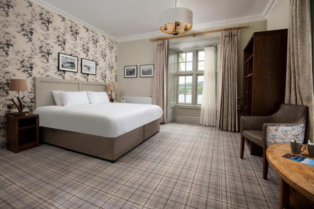 Habitación de hotel con cama y silla en The Waterhead Inn- The Inn Collection Group en Ambleside