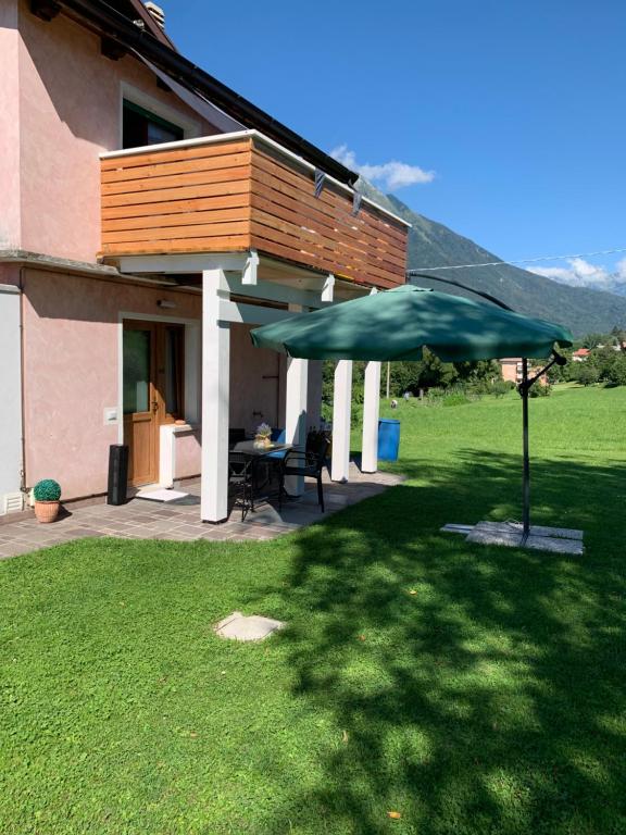 een huis met een patio met een groene parasol bij Casa S. Caterina 