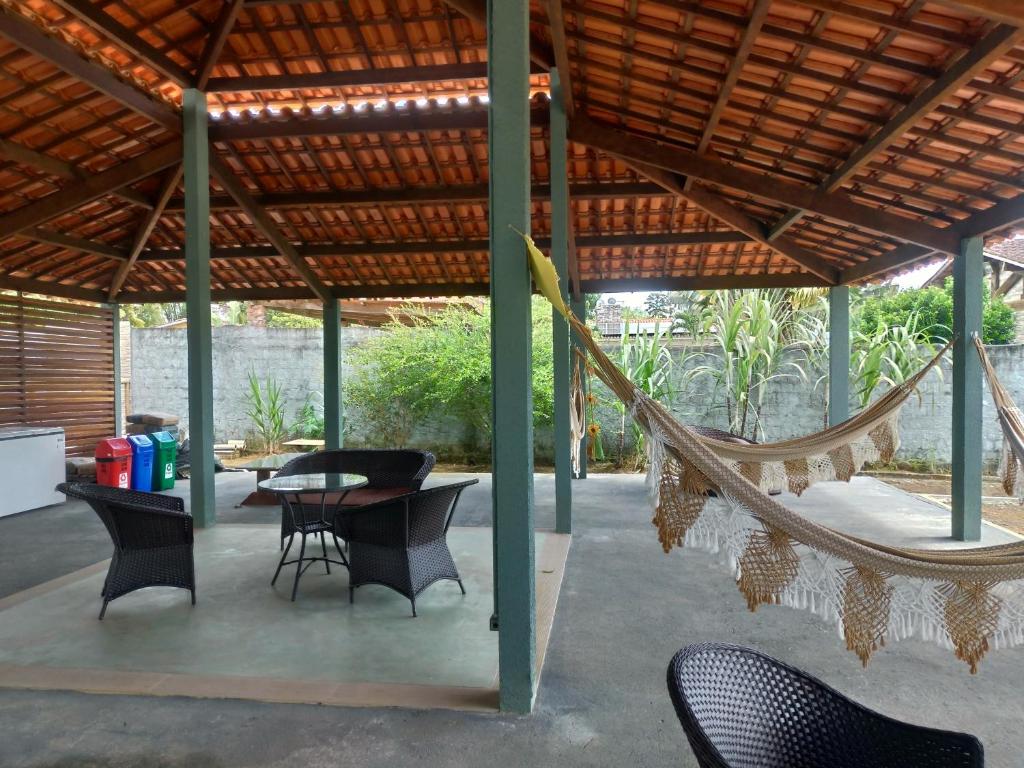 eine Terrasse mit einer Hängematte sowie Tischen und Stühlen in der Unterkunft Refúgio em Aldeia dos Camarás in Camaragibe