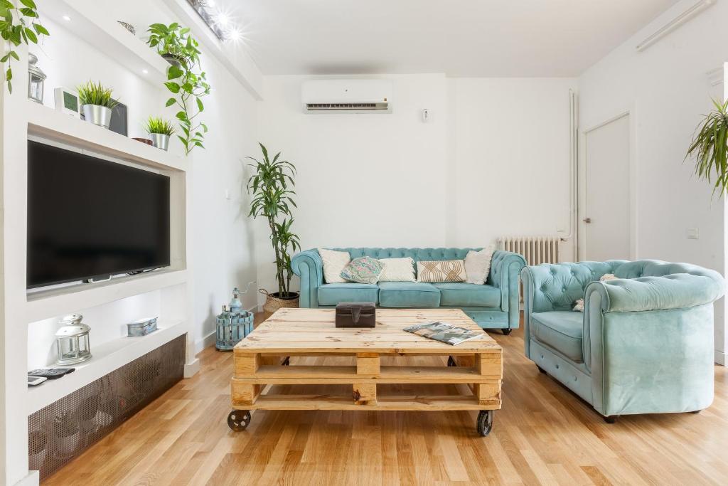 Sala de estar con 2 sofás azules y mesa de centro en Via Augusta, en Barcelona