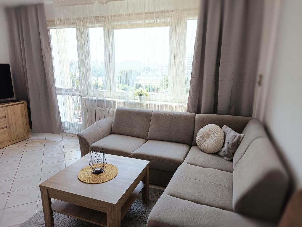 a living room with a couch and a coffee table at Korczaka Skyline in Elblag