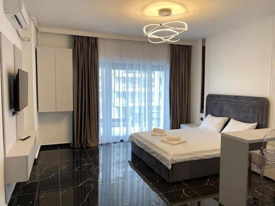 a bedroom with a bed and a large window at Vista del Mar in Mamaia