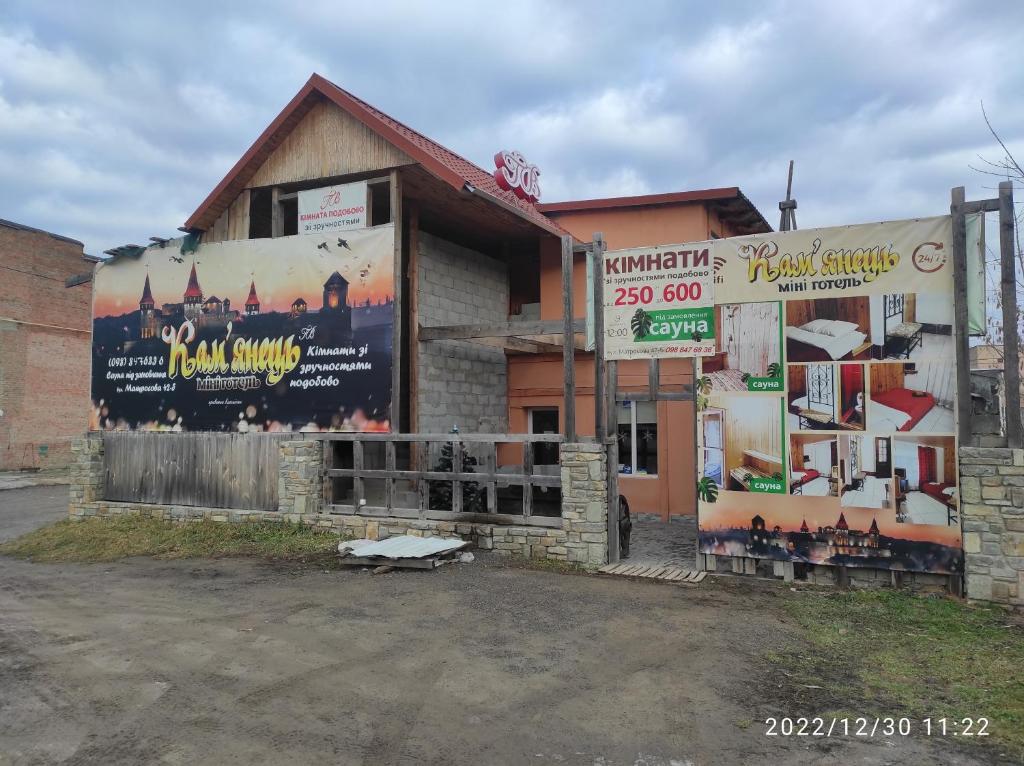 a building with signs on the side of it at Mini-hotel Kamianets in Kamianets-Podilskyi