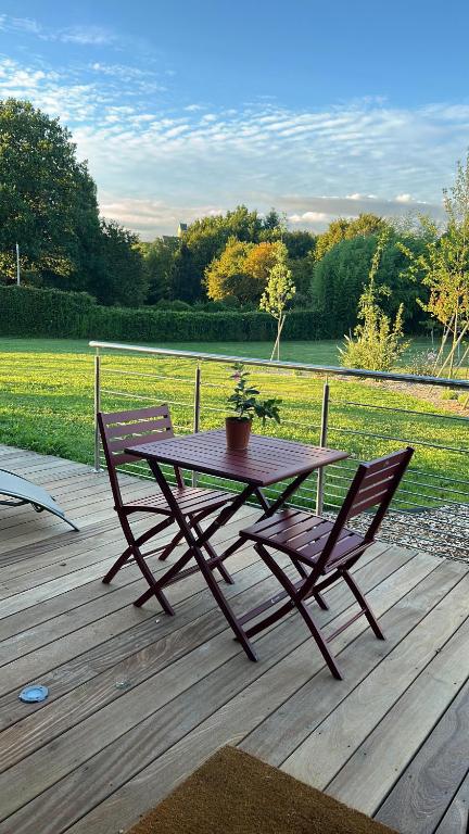a wooden table and two chairs on a wooden deck at Sol&#39;m Lodges in Solesmes