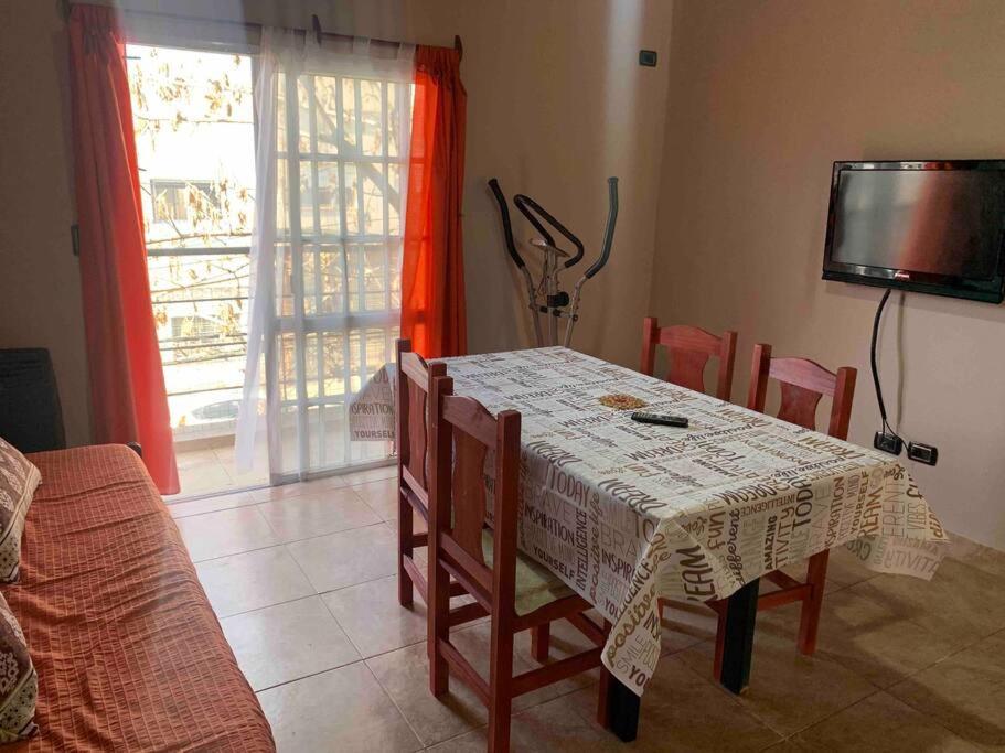 une salle à manger avec une table, des chaises et une télévision dans l'établissement Departamento en Campana, à Campana