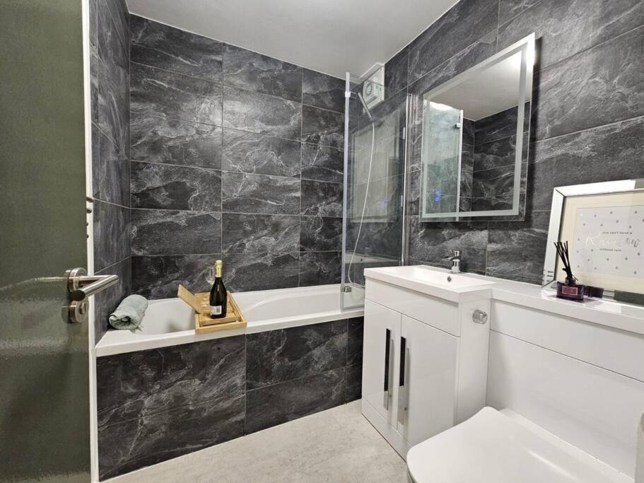 uma casa de banho com um lavatório, uma banheira e um WC. em Cozy and Modern Apartment in Central Reading with Free Parking, WIFI and NETFLIX em Reading