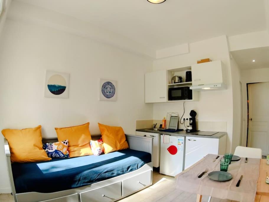 uma sala de estar com um sofá e uma mesa em Appartement à 30 minutes de Disney et de Paris em Fontenay-sous-Bois