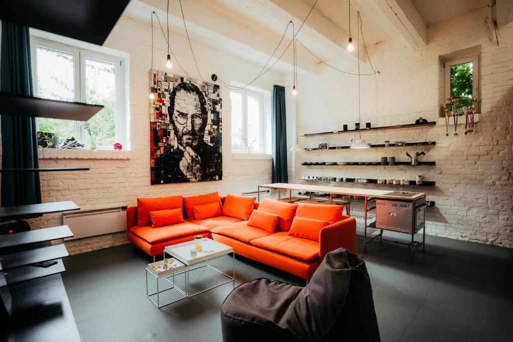 a living room with an orange couch and a table at Smaltovňa Loft D in Lučenec