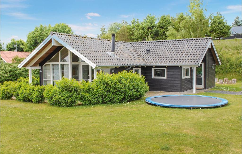 a house with a trampoline in front of it at Gorgeous Home In Ebeltoft With Wifi in Ebeltoft