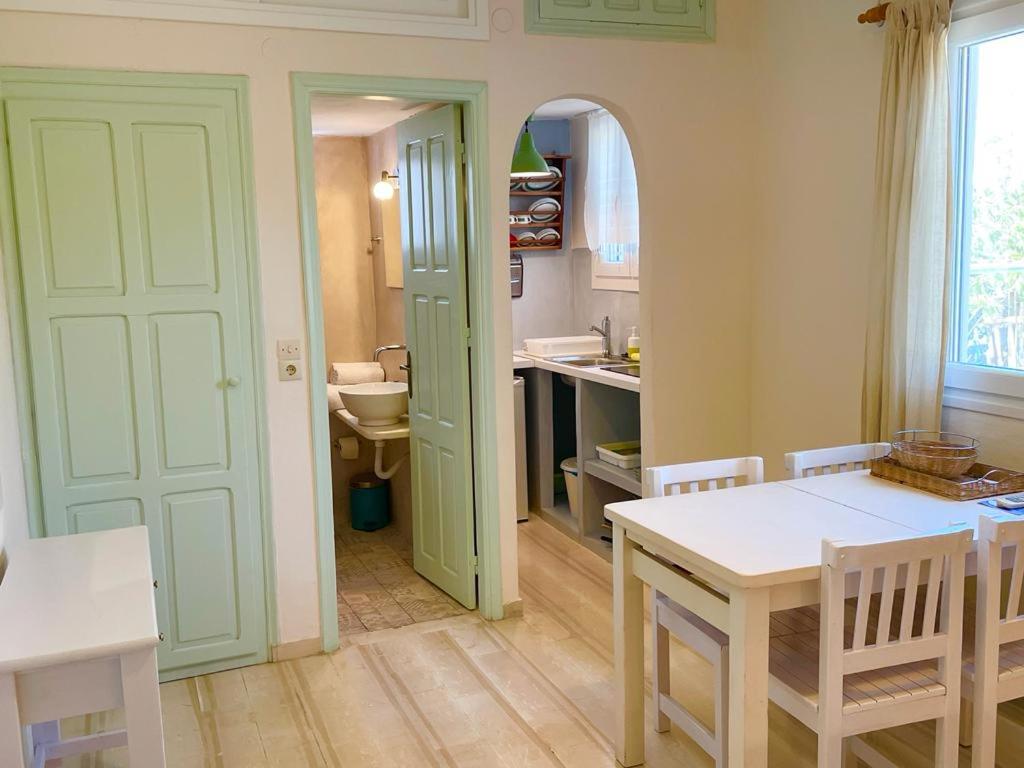 una cucina con tavolo e un bagno con lavandino di Lilo's Apartments a Livadi Astypalaias