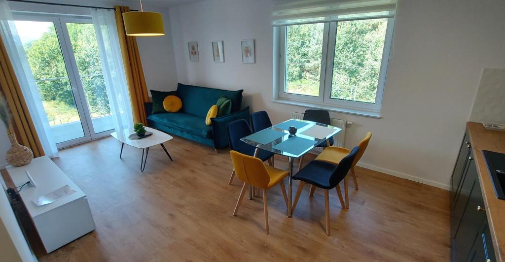a living room with a table and chairs and a couch at Allewidok 2 in Jelenia Góra
