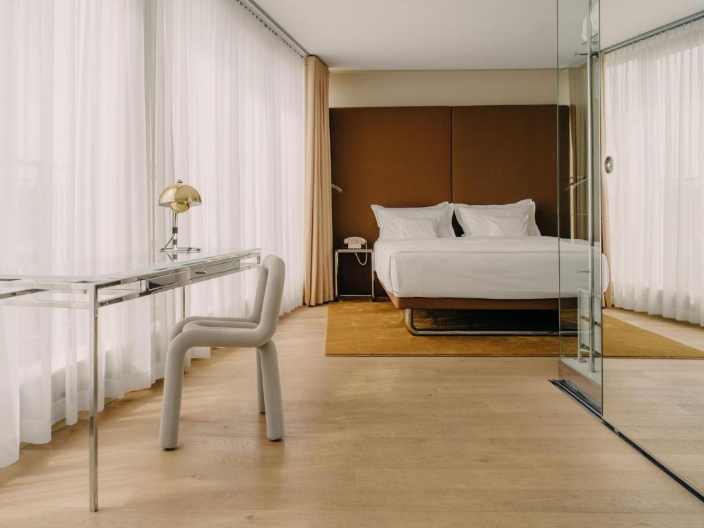 a bedroom with a bed and a glass desk at Hotel Josef in Prague