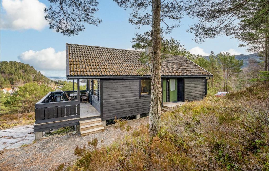 a small house on a hill with a deck at Nice Home In Valevg With Sauna And 2 Bedrooms in Valevåg