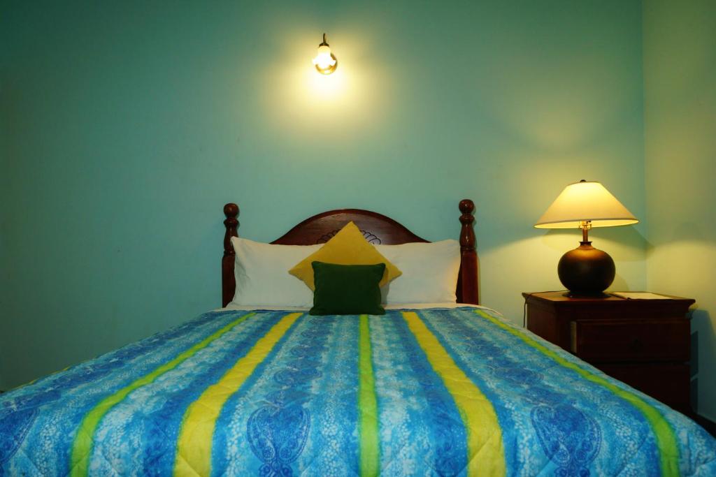 a bedroom with a bed with a blue and yellow blanket at Lamblion Holiday Apartment in Freemans