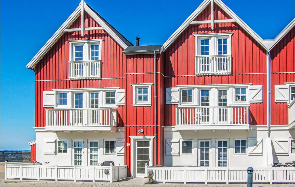 un edificio rojo y blanco con el océano al fondo en 2 Bedroom Cozy Apartment In Bagenkop, en Bagenkop