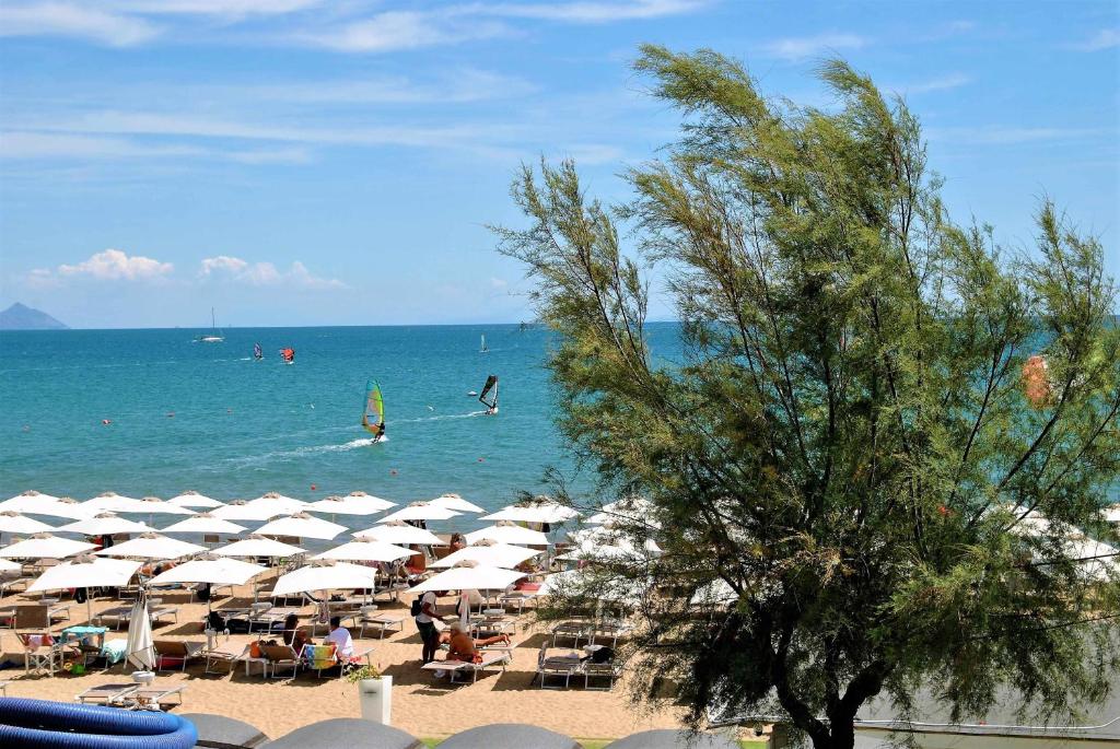 ein Strand mit Sonnenschirmen und Menschen im Wasser in der Unterkunft Brezza di mare appartamento fronte spiaggia in Formia