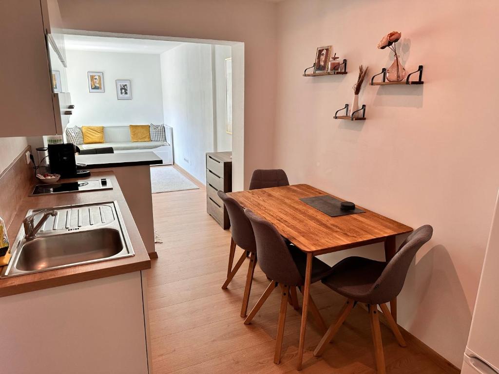 uma pequena cozinha com uma mesa de madeira e cadeiras em Holiday apartment in Gmunden 