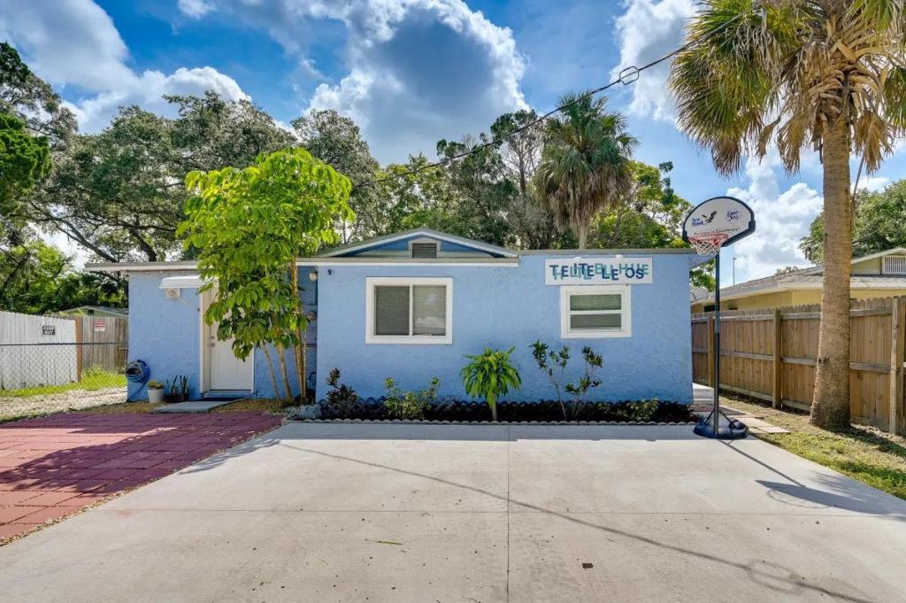 una casa azul con un cartel delante en The Little Blue House - Pet Friendly! Fenced Backyard with Tiki Bar & Fire Pit en Hudson