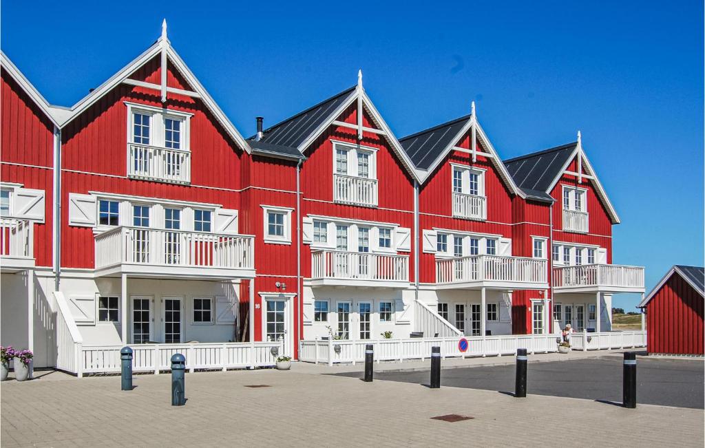 un grande edificio rosso con balconi bianchi di Beach Front Apartment In Bagenkop With Kitchen a Bagenkop