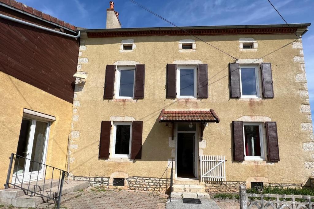 an old brick building with windows and a door at Les Gites de Louisette 1886 in Ébreuil