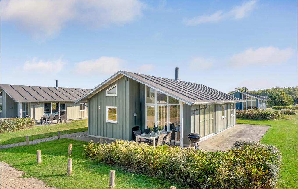 ein grünes modulares Haus mit Terrasse und Rasen in der Unterkunft Gorgeous Home In Nrre Nebel With Wifi in Lønne Hede