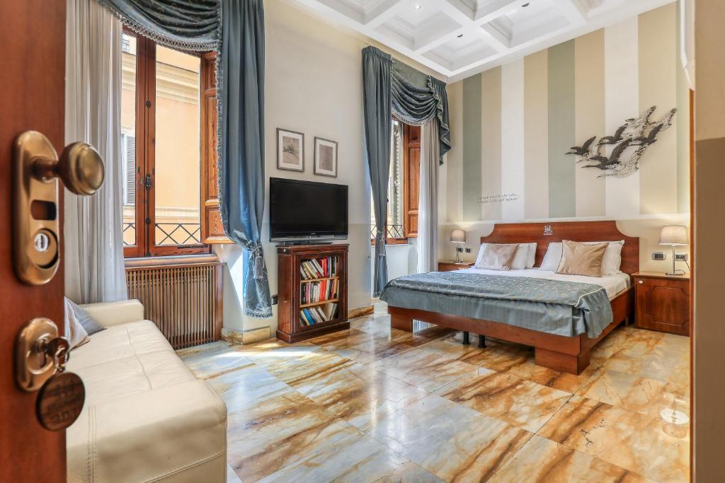 una camera con letto, TV e divano di Spagna Dream Suites a Roma