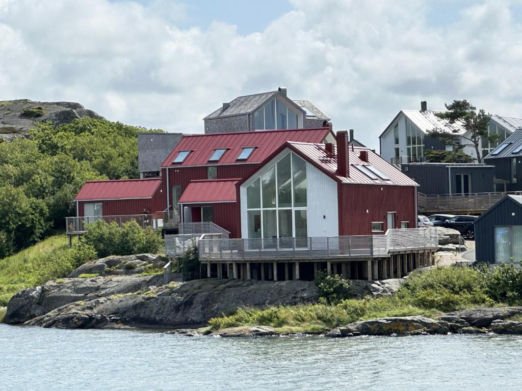 ein rotes und weißes Haus am Ufer eines Wasserkörpers in der Unterkunft Unique holiday home 10 meters from the water at Lilla Fjellsholmen in Kärna