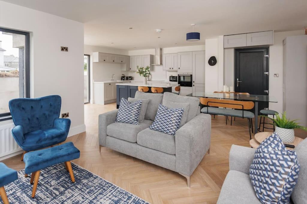 ein Wohnzimmer mit einem Sofa und Stühlen sowie eine Küche in der Unterkunft The Views Cottage in Newcastle