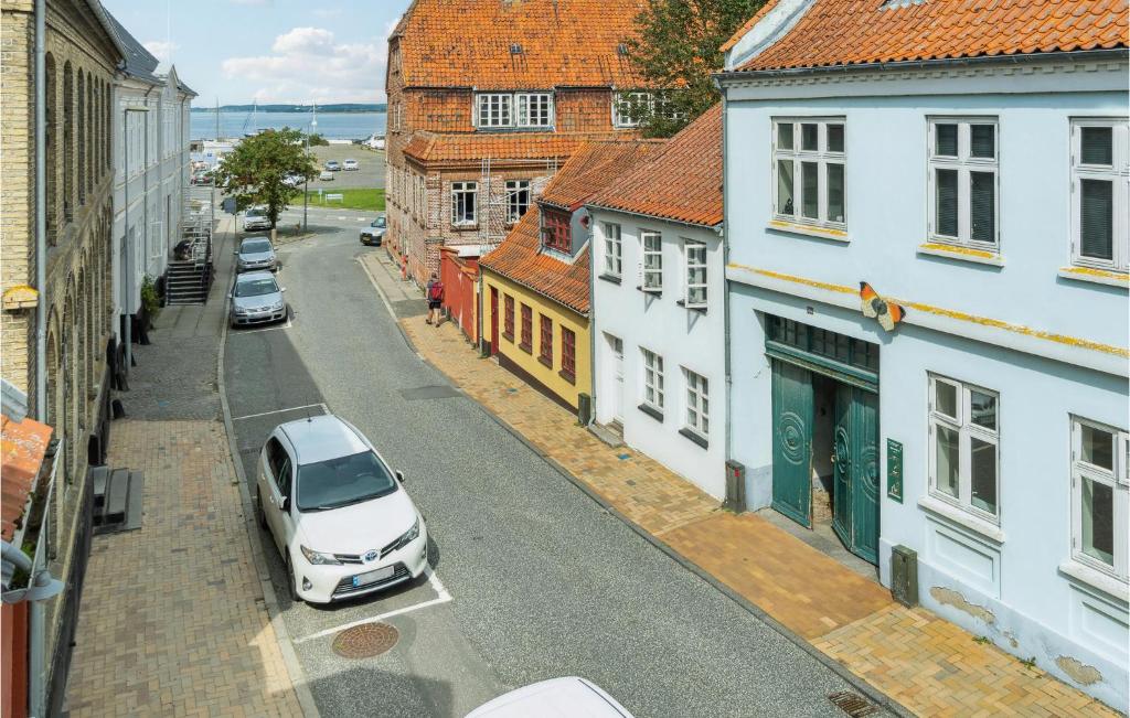 un coche blanco aparcado en una calle con edificios en Pet Friendly Home In Rudkbing With Kitchen, en Rudkøbing