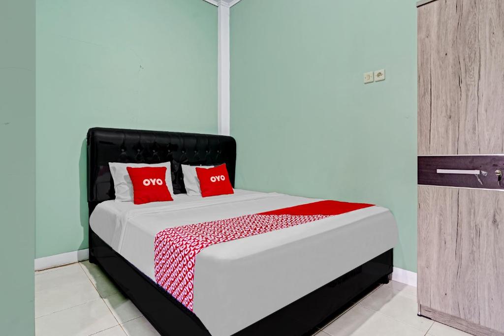 سرير أو أسرّة في غرفة في OYO 90571 Dewi Guest House Syariah