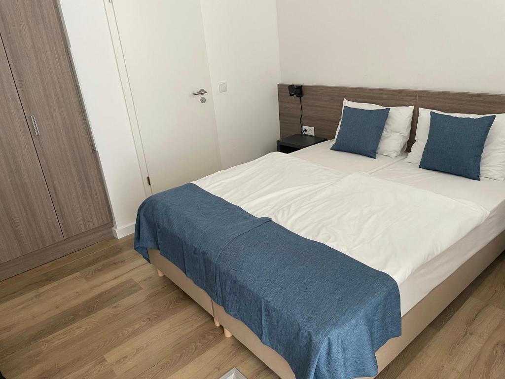 a bedroom with a large bed with blue pillows at RES City Residence Hotel Budapest in Budapest