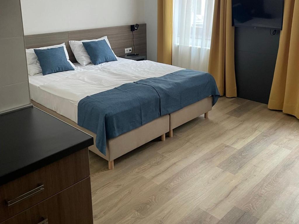 a bedroom with a large bed with blue pillows at RES City Residence Hotel Budapest in Budapest
