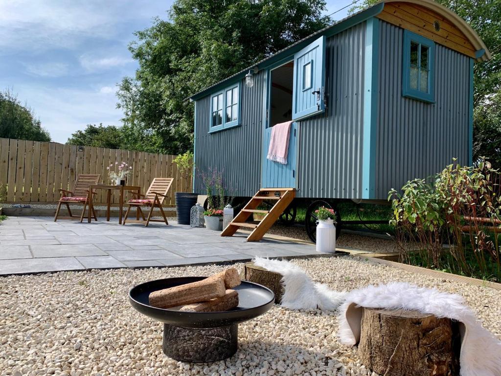 a tiny house in a garden with a table and chairs at St. Kew Shepherd Huts in Wadebridge