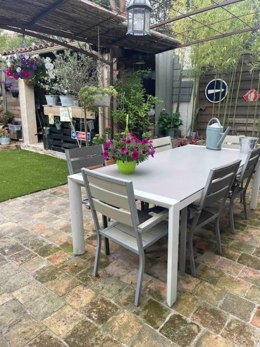 - une table et des chaises blanches fleuries sur la terrasse dans l'établissement Très belle villa , calme et cosy ,6 personnes 10 mns des plages, à Martigues