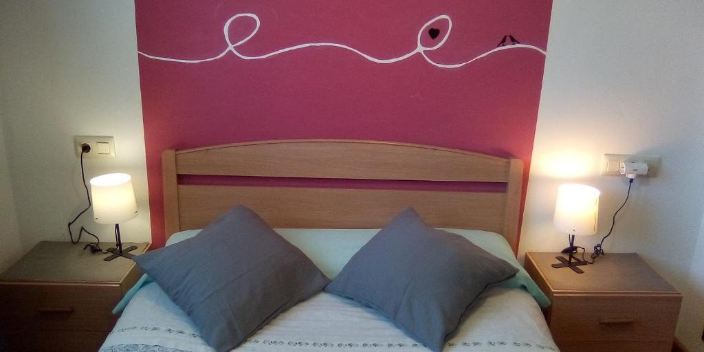 1 dormitorio con 1 cama con pared de color rosa en Apartamento Valdesquí, en Valdelinares