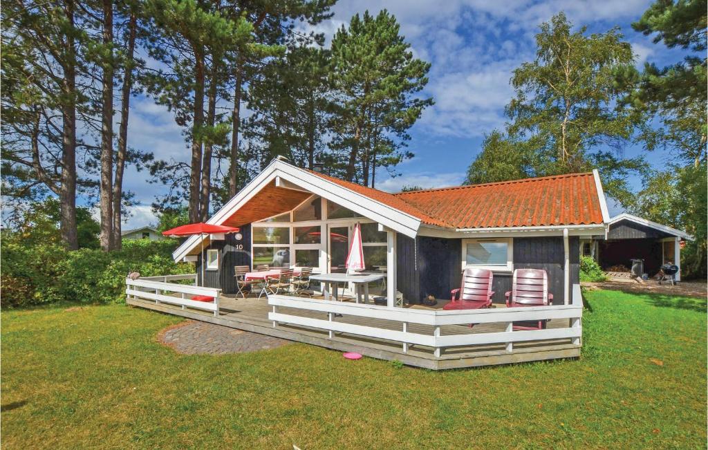 オテルプにあるNice Home In Otterup With 3 Bedrooms, Sauna And Wifiの小さな家で、デッキ(椅子、テーブル付)が備わります。