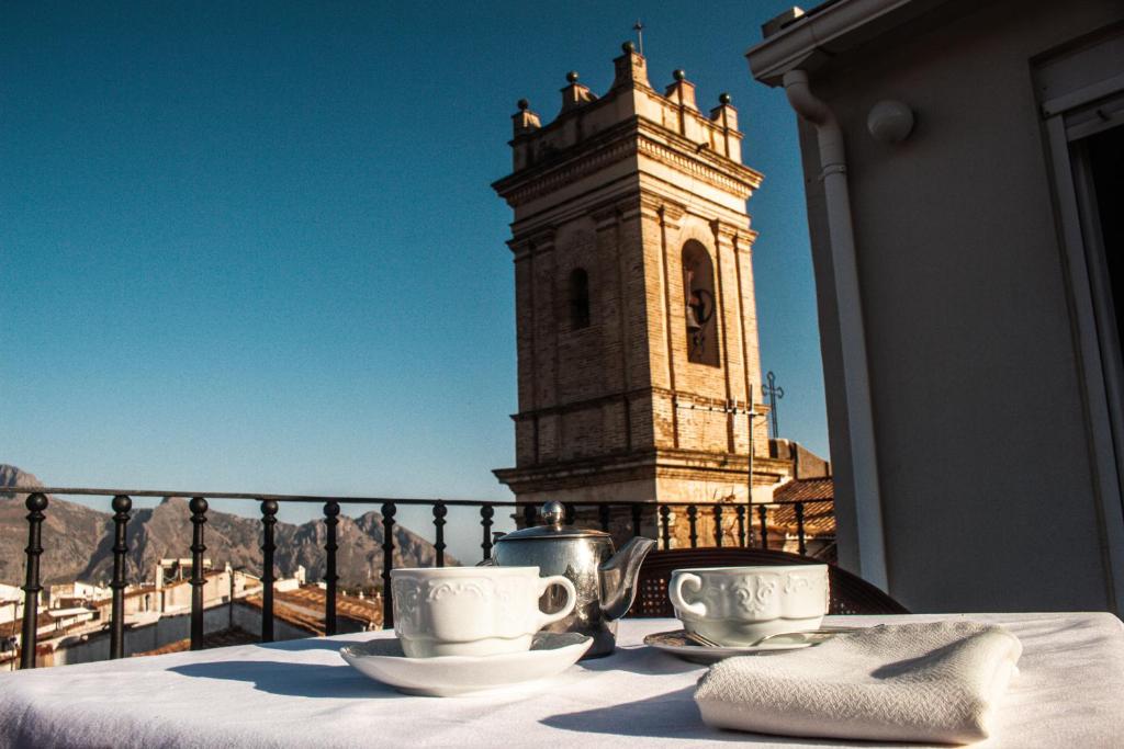 a table with two cups and a clock tower at Hotel Tàrbena in Tárbena