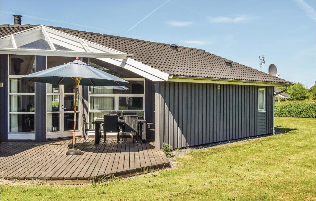 SpodsbjergにあるStunning Home In Rudkbing With Saunaの傘付きのデッキのある家