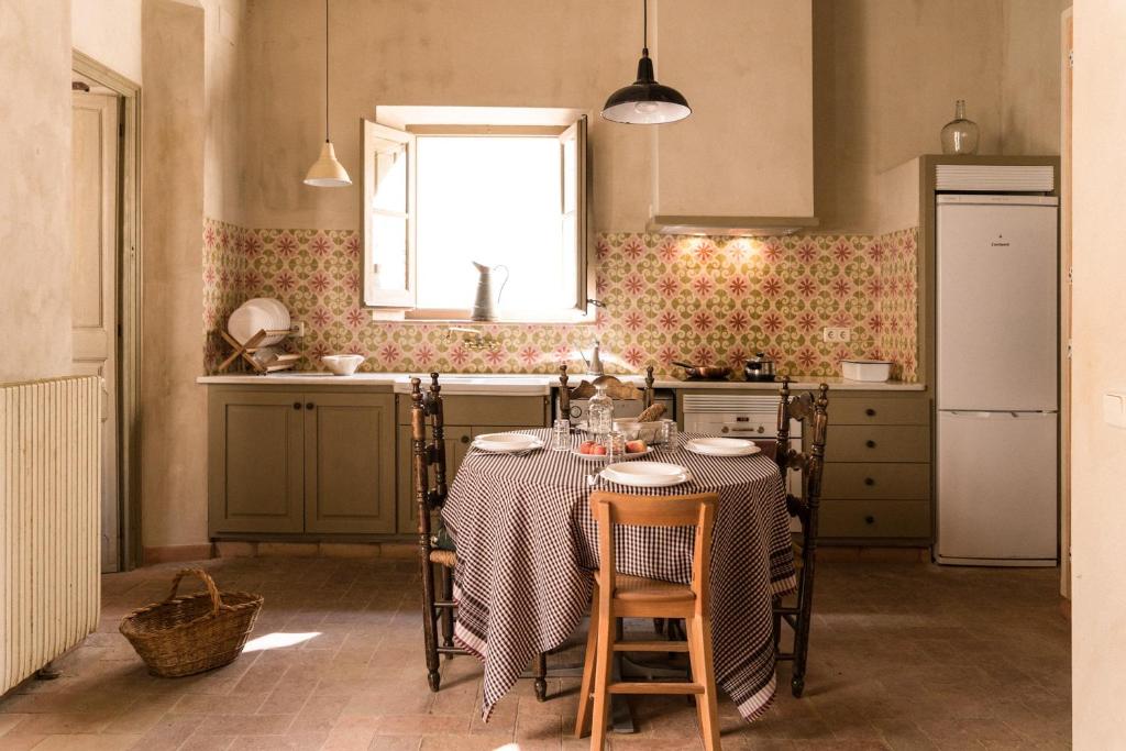 cocina con mesa con sillas y ventana en Ca la Merce Batista, en Palau-saverdera