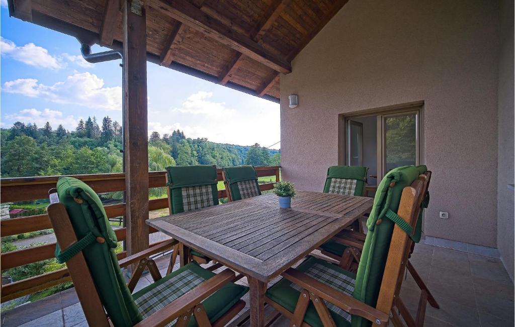 a wooden table and chairs on the deck of a house at Awesome Home In Donji Zvecaj With Wifi in Donji Zvečaj