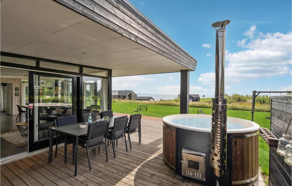 a deck with a hot tub and a table and chairs at Amazing Home In Haderslev With Kitchen in Kelstrup Strand