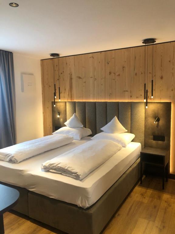 1 dormitorio con 1 cama grande y cabecero grande en Pra Ciarea Apartments en Ortisei
