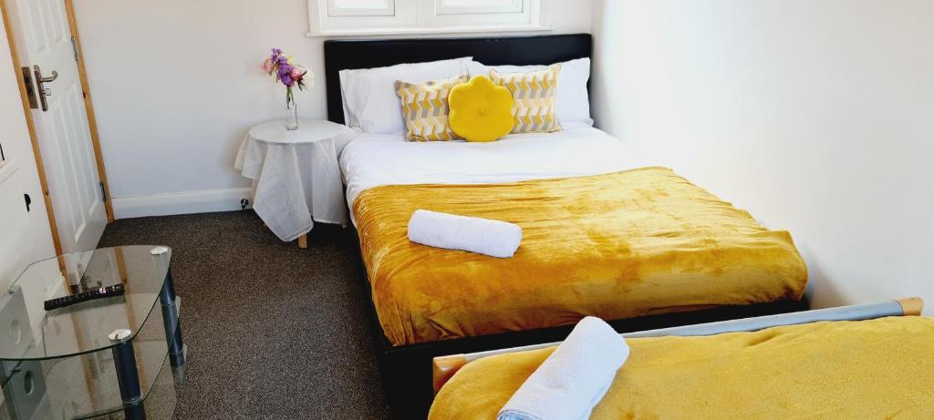 una camera con due letti e un cuscino giallo sul letto di Browning House I Long or Short Stay I Special Rate Available a Derby