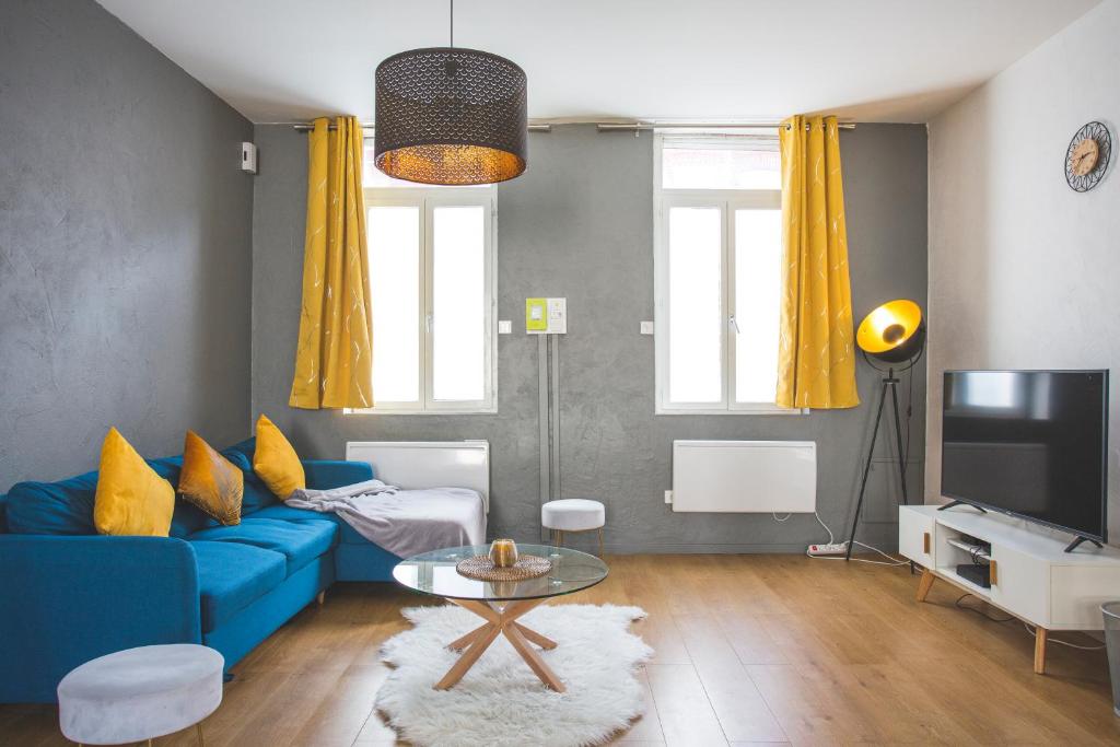 sala de estar con sofá azul y TV en Colocation de luxe à Tourcoing avec jardin en Tourcoing