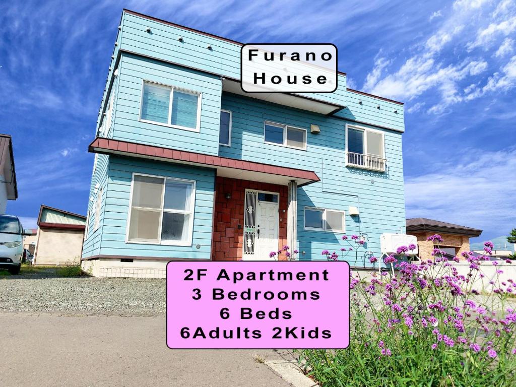 una casa azul con un cartel delante en Furano House, JR Station, 2F Apartment, 3 Bedrooms, Max 8PP - 6 Adults 2 Kid, Onsite Parking en Furano