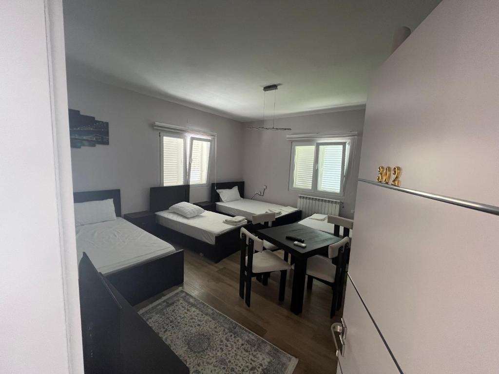 Habitación pequeña con 2 camas y mesa. en Bujtina cela en Berat
