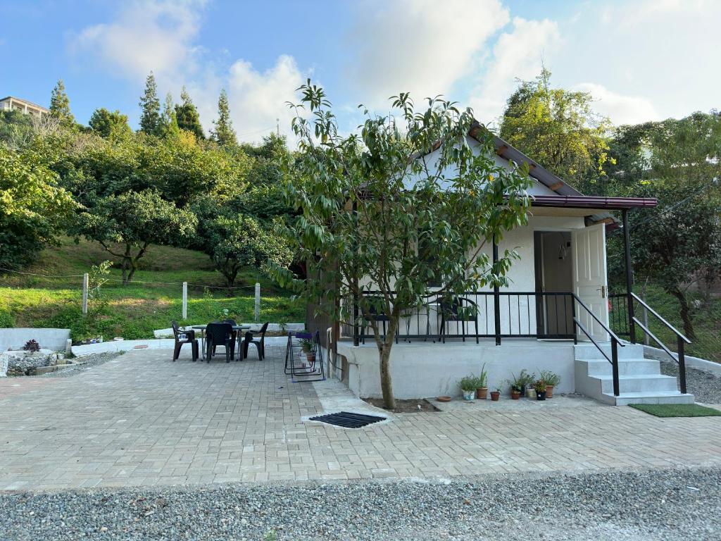 eine Terrasse mit einem Tisch und einem Baum vor einem Haus in der Unterkunft BANI tsikhisdziri in Zichisdsiri