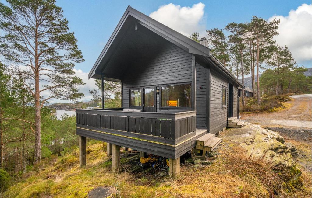 Ein schwarzes kleines Haus auf einem Hügel im Wald. in der Unterkunft Stunning Home In Valevg With Kitchen in Valevåg