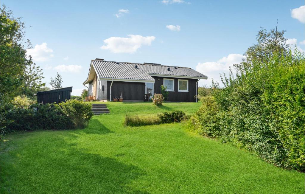 a house with a green yard in front of it at 3 Bedroom Nice Home In Kalundborg in Kalundborg